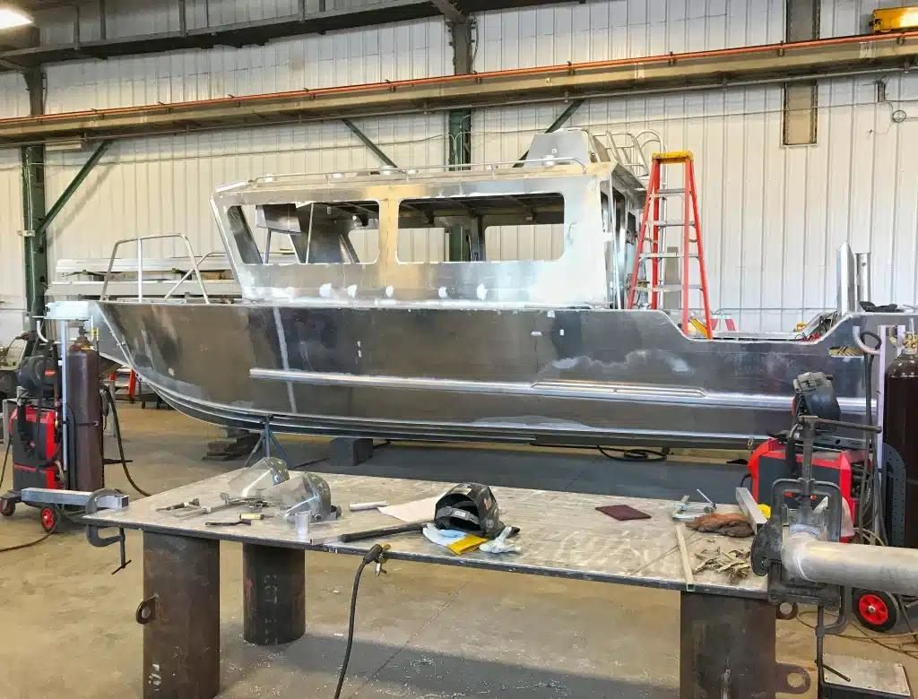Fabricator working on aluminum boat structure with high frequency TIG setup