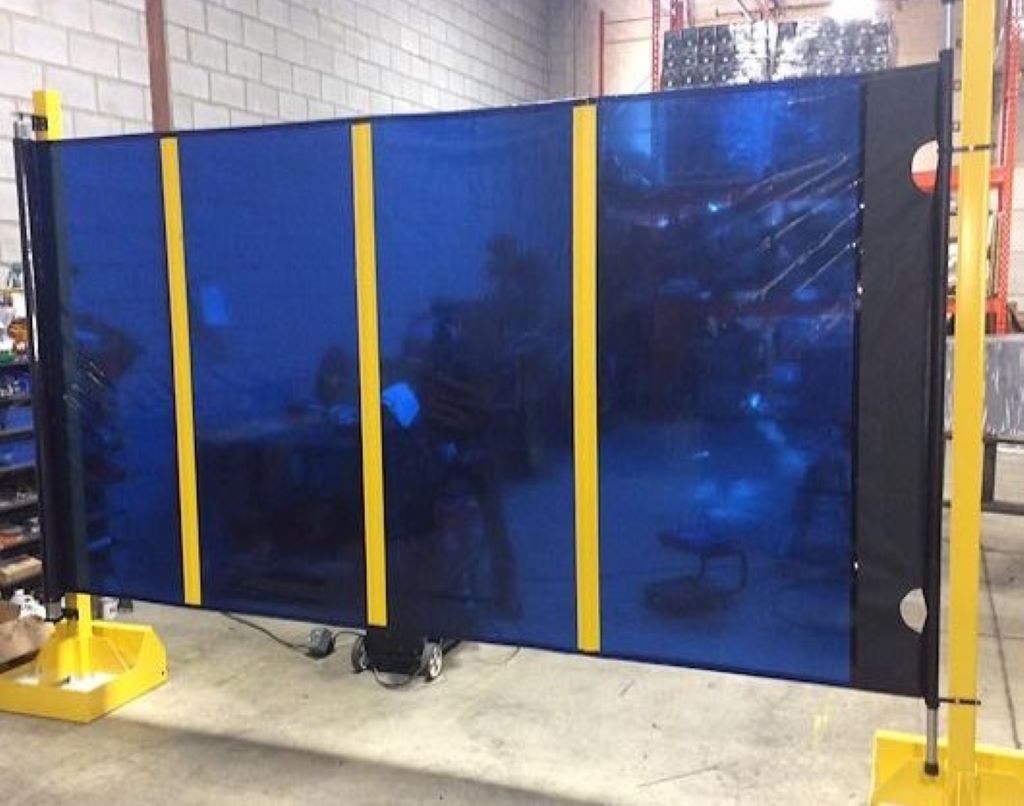 Industrial welding curtain tied to steel frame with ground anchors